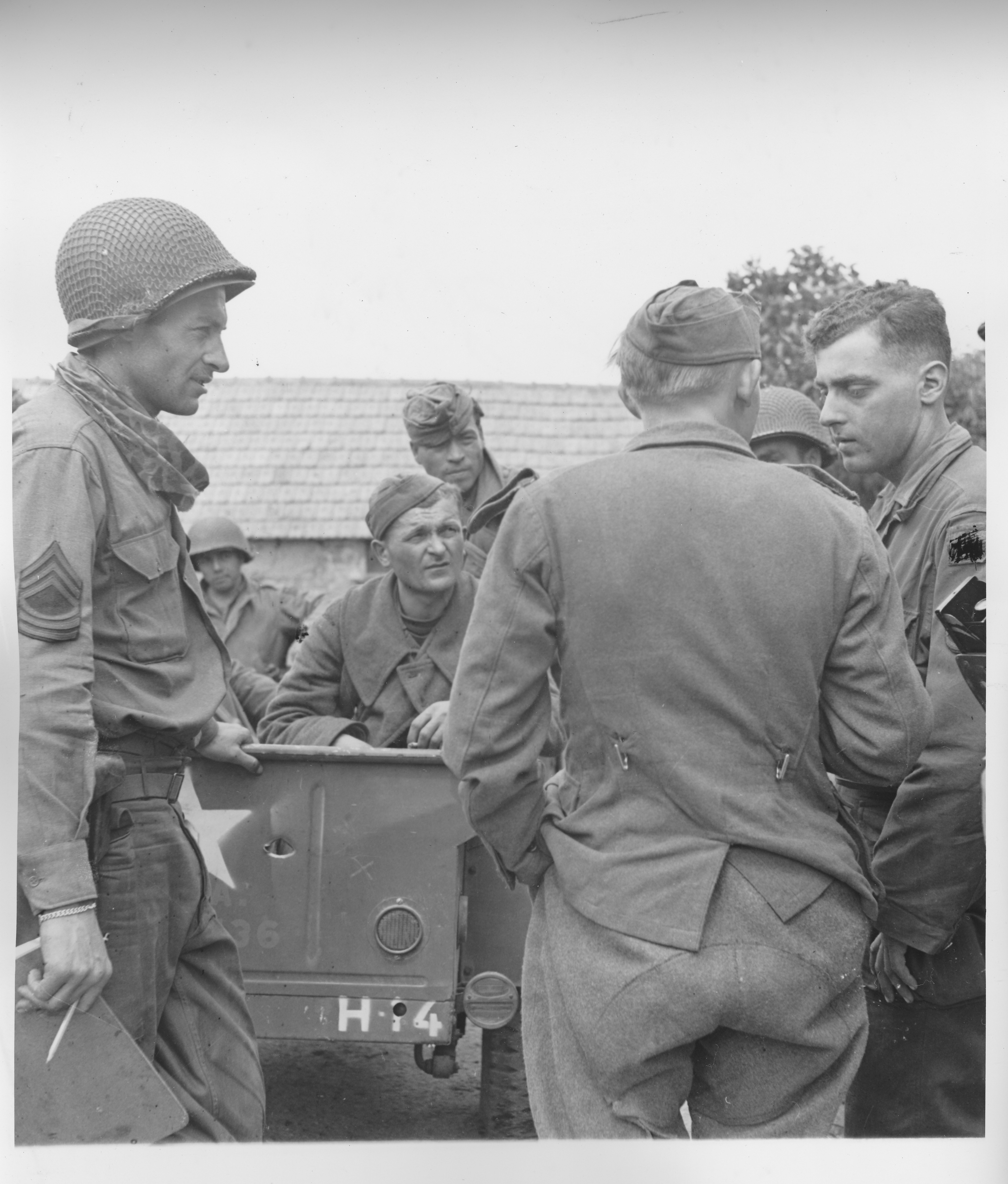 Signal Corps SC 293325 (Yank): M/Sgt Ted Henning (Newark, N.J.) and S/Sgt Walt Strauss (Jamaica, L.I.) with escaped Russian soldier, Cherbourg, July 1944 — IPW Team 49.